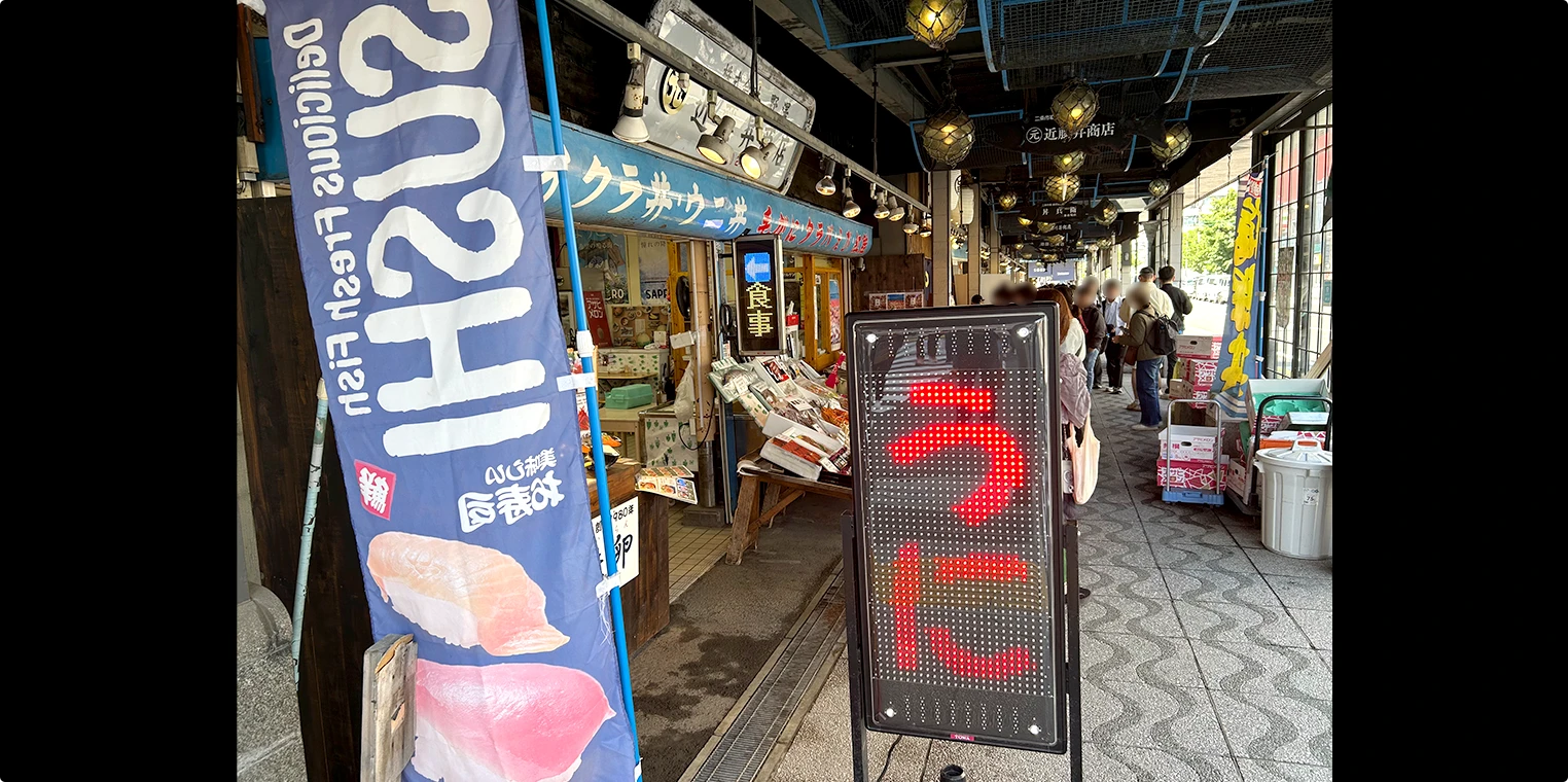市場内の通路。「うに」の電光看板が光る