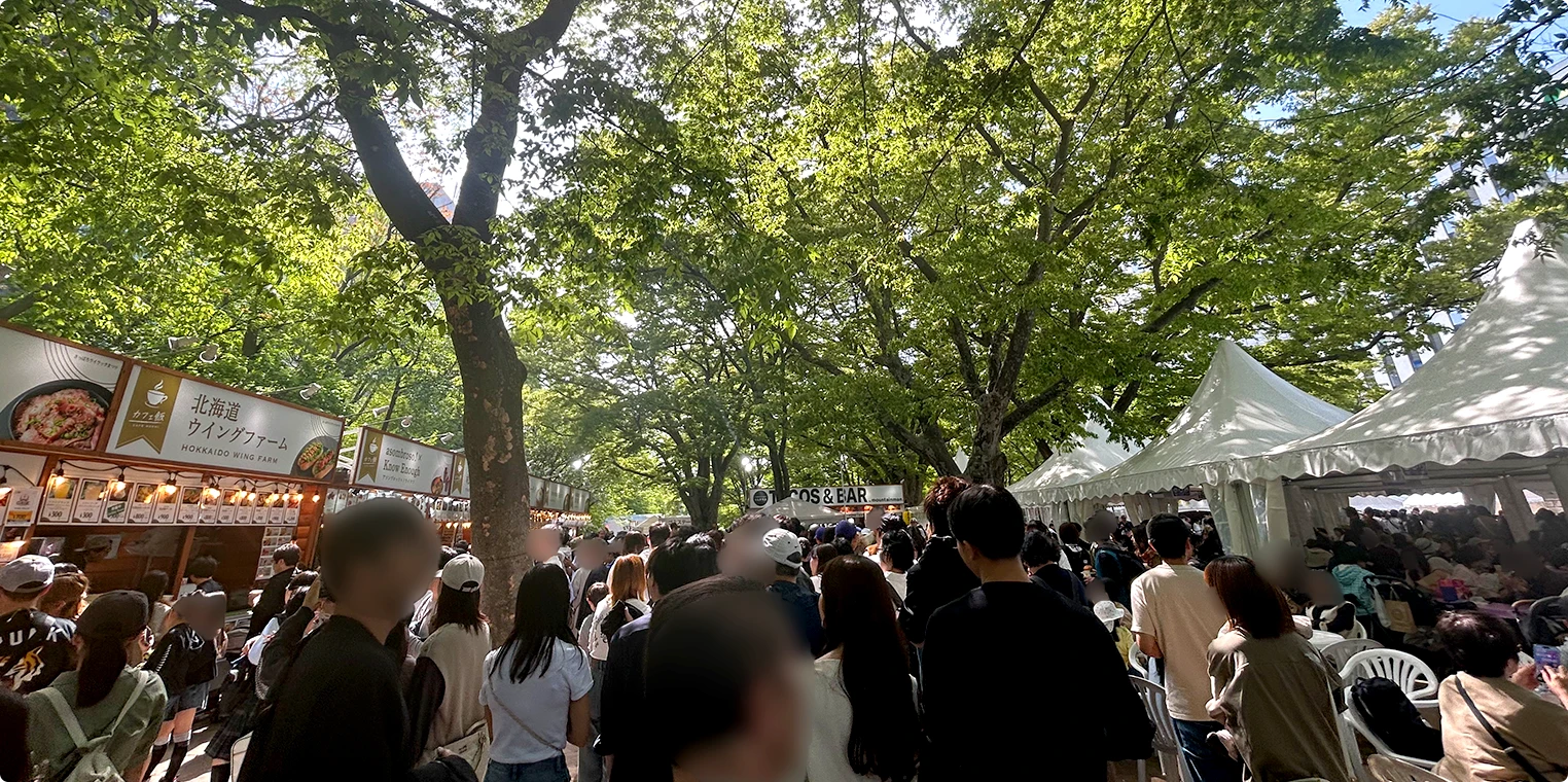 大通公園のイベント開催時の様子。屋台と木陰に大勢の人が集まっている