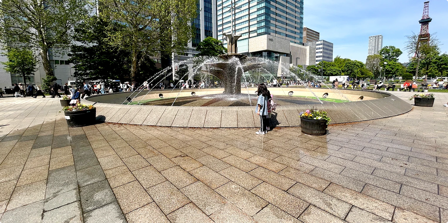 大通公園の噴水そば。テレビ塔を背景に噴水が勢いよく上がっている